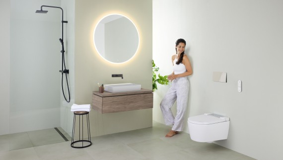 Woman in front of bathroom mirror (© Geberit) Woman in front of bathroom mirror (© Geberit)