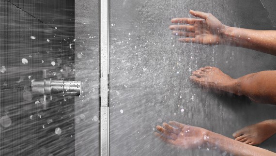 Person showering in a floor-even shower with CleanLine Person showering in a floor-even shower with CleanLine