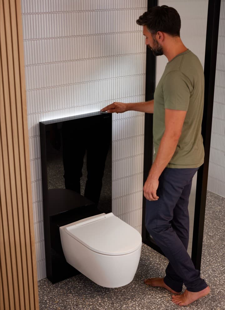 Man next to Geberit Monolith Plus with ComfortLight Man next to Geberit Monolith Plus with ComfortLight